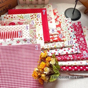 Könnte beinhalten: Eine Sammlung von 14 roten und weißen Stoffquadraten mit verschiedenen Mustern, darunter Punkte, Streifen und Blumenmuster. Die Quadrate sind von 1 bis 14 nummeriert. Der Text "Fabricmade.etsy.com" ist in der rechten unteren Ecke sichtbar.