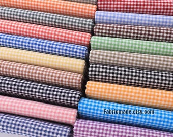 May include: A stack of 20 different colored gingham fabrics with white checks. The fabrics are arranged in a rainbow pattern. The fabric is perfect for quilting, sewing, and crafting.