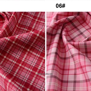 May include: Two swatches of pink and red plaid fabric. The fabric on the left has a 3 cm grid pattern. The fabric on the right has a 4 cm grid pattern.