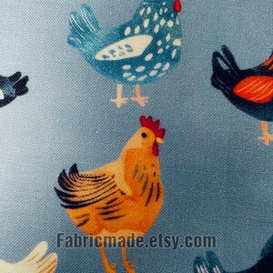 May include: A light blue fabric featuring a repeating pattern of chickens in various colors including yellow, blue, and black, each with a red comb. The text Fabricmade.etsy.com is printed in black across the lower center of the textile surface.