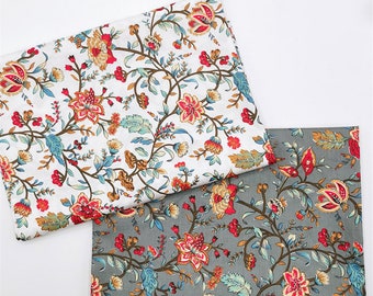 May include: Two pieces of fabric with a floral pattern. One piece is white with a light brown, red, and blue floral pattern. The other piece is gray with a dark brown, red, and blue floral pattern.