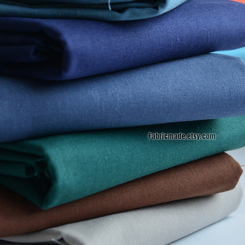 May include: A stack of six different colored fabric swatches. The colors are teal, dark blue, light blue, brown, gray, and a darker shade of blue. The fabric is smooth and has a slight sheen. The text "Fabricmade.etsy.com" is visible on the bottom right corner of the image.