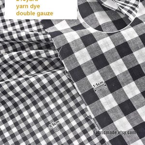 May include: Black and white gingham double gauze fabric. The fabric is 59 inches wide and made of 100% cotton. The image includes text that reads "2 black", "100% cotton", "59"/145cm", "215yard", "yarn dye", and "double gauze".