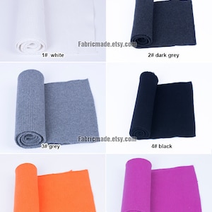 Op de afbeelding: Zes rollen geribbelde breisels in verschillende kleuren, waaronder wit, donkergrijs, grijs, zwart, oranje en roze. De stof is opgerold en op een witte achtergrond gelegd. De tekst "Fabricmade.etsy.com" is zichtbaar in de afbeelding.