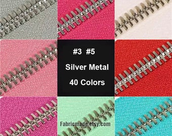 May include: Close-up of a silver metal zipper with teeth on different colored fabrics. The zipper is available in 40 colors. #3 #5 Silver Metal 40 Colors Fabricmade.etsy.com