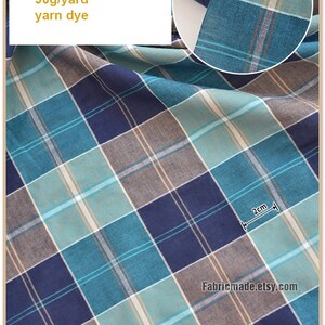 May include: A close-up of a blue, green, and brown plaid fabric. The fabric is 100% cotton and measures 44 inches by 112 centimeters. The fabric is 90 grams per yard and is yarn dyed.
