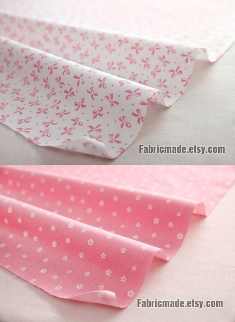 May include: Two pieces of pink fabric with white patterns. The top piece has a white background with pink bows. The bottom piece has a pink background with white flowers. Fabricmade.etsy.com is printed on both pieces.
