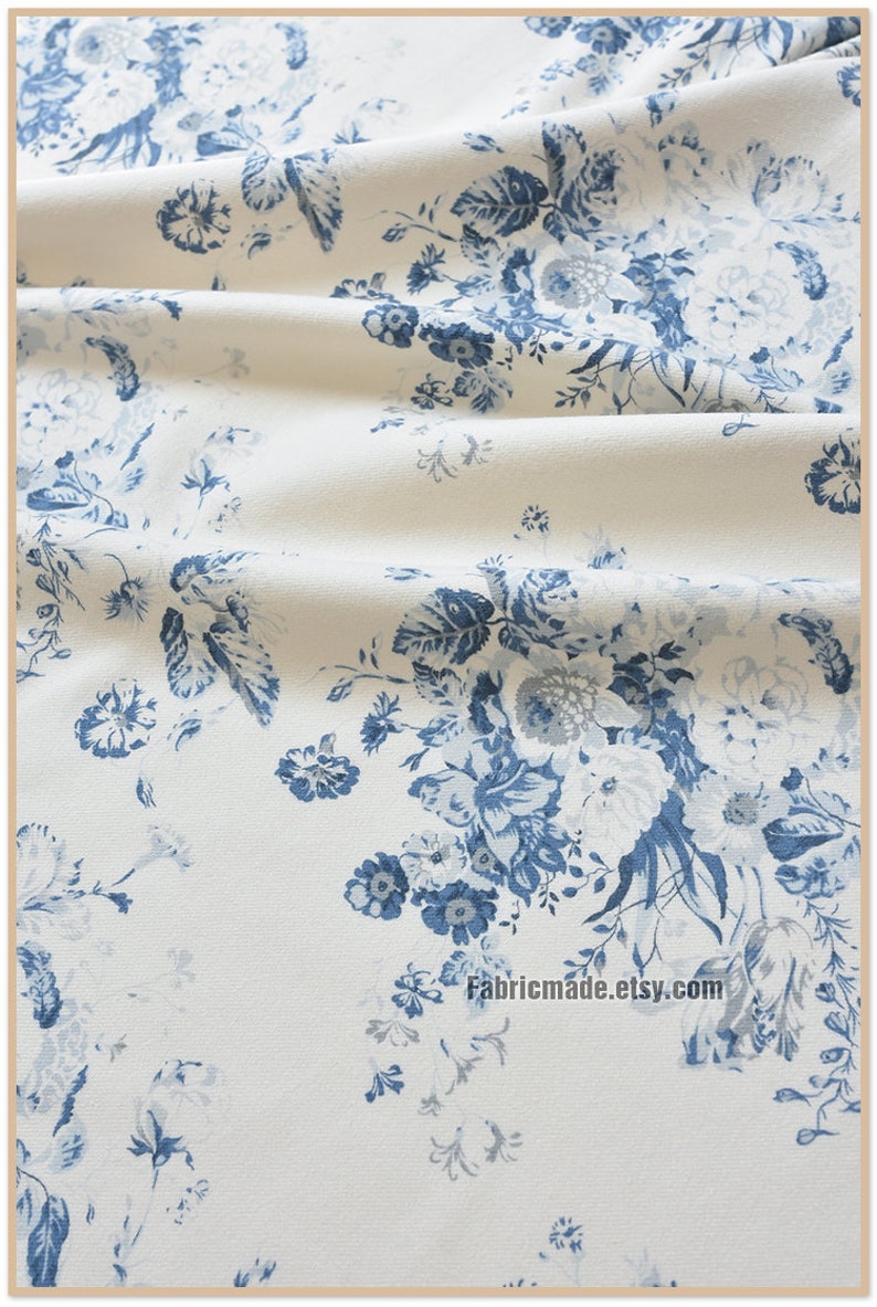 Puede incluir: Tela blanca con un patr&oacute;n floral azul. La tela tiene una textura sutil y una apariencia ligeramente arrugada. El patr&oacute;n floral presenta flores azules, hojas y tallos. El texto "Fabricmade.etsy.com" es visible en la esquina inferior derecha de la imagen.