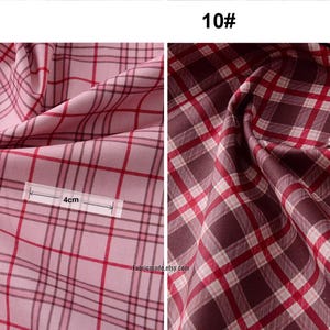 May include: Two fabric swatches with a red and white plaid pattern. The swatch on the left is pink and the swatch on the right is brown. The swatch on the left has a measurement of 4 inches and the swatch on the right has a measurement of 3 inches.