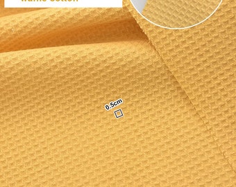 Tela de algodón con textura de gofre, rosa, verde, dorado y amarillo, suave y de peso medio.