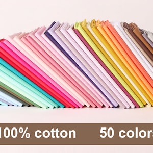 May include: A collection of 50 fabric swatches in various colours, arranged in a fan shape. The fabric is 100% cotton.