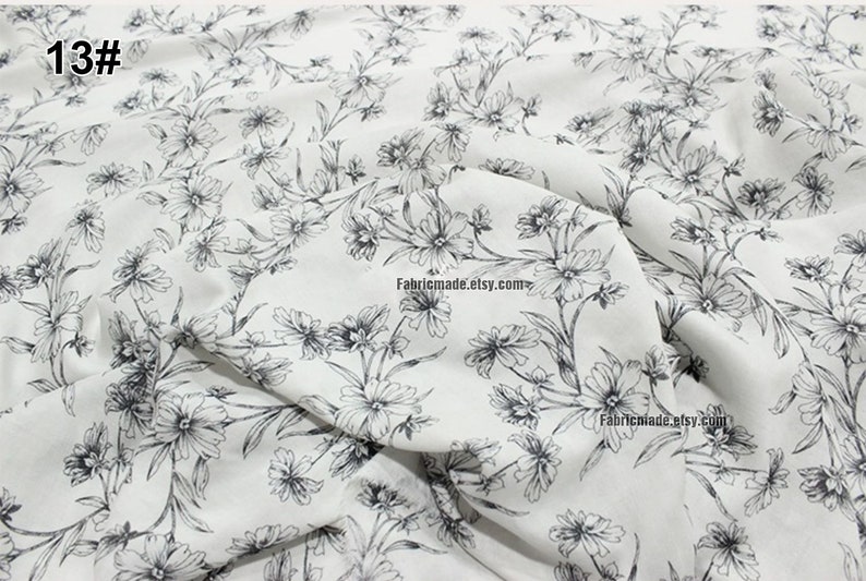 Peut inclure: Tissu blanc avec un imprim&eacute; floral noir. Le tissu a une texture subtile et une sensation douce et fluide. Les fleurs sont petites et d&eacute;licates, et elles sont dispos&eacute;es en un motif r&eacute;p&eacute;titif. Le tissu est parfait pour une vari&eacute;t&eacute; de projets de couture, tels que des robes, des jupes, des chemisiers et de la d&eacute;coration int&eacute;rieure.