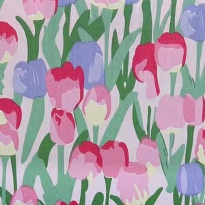 May include: A white background with a repeating pattern of pink, red, and purple tulips with green stems and leaves.