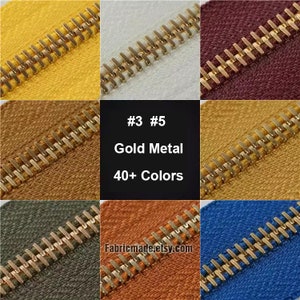 Può includere: Primo piano di cerniere in metallo dorato in vari colori, tra cui giallo, bianco, rosso, marrone, arancione e blu. Il testo "#3 #5 Gold Metal 40+ Colors Fabricmade.etsy.com" è visibile al centro dell'immagine.