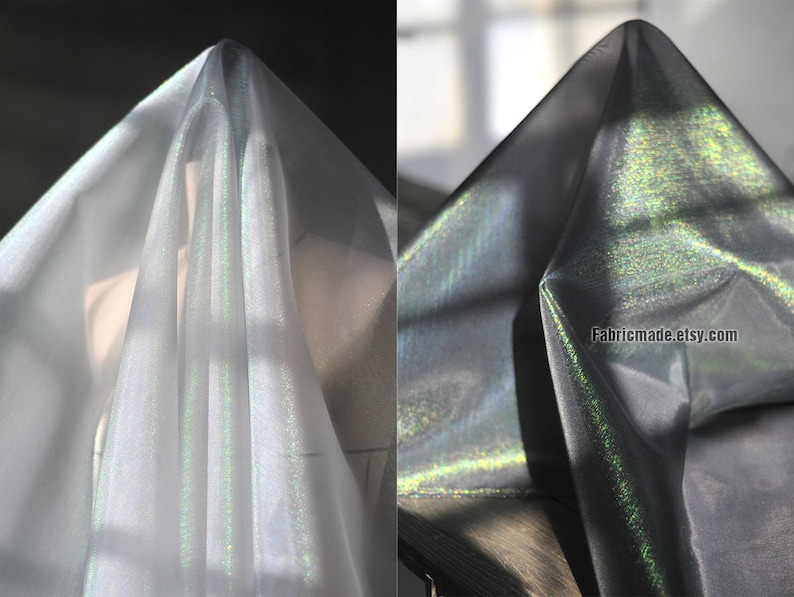 May include: Two images of iridescent fabric. The fabric is draped, creating folds and shadows. The fabric appears to shift colors, with hints of green and silver. The fabric is semi-transparent, allowing light to pass through. The Etsy shop name "Fabricmade.etsy.com" is visible.
