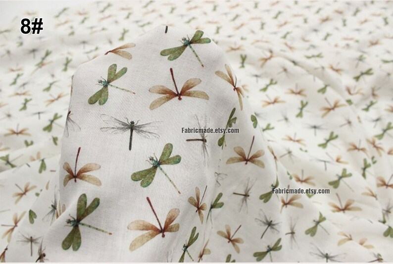May include: White fabric with a repeating pattern of brown and green dragonflies. The fabric has the text "Fabricmade.etsy.com" printed on it.