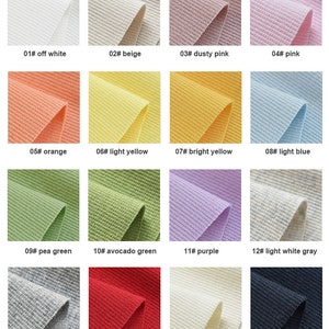 K&ouml;nnte beinhalten: Farbkarte mit 16 verschiedenen Farben von geripptem Stoff. Die Farben sind cremewei&szlig;, beige, staubiges Rosa, rosa, orange, hellgelb, leuchtend gelb, hellblau, erbsengr&uuml;n, avocadogr&uuml;n, lila, hellgrau, grau, rot, elfenbein und marineblau.