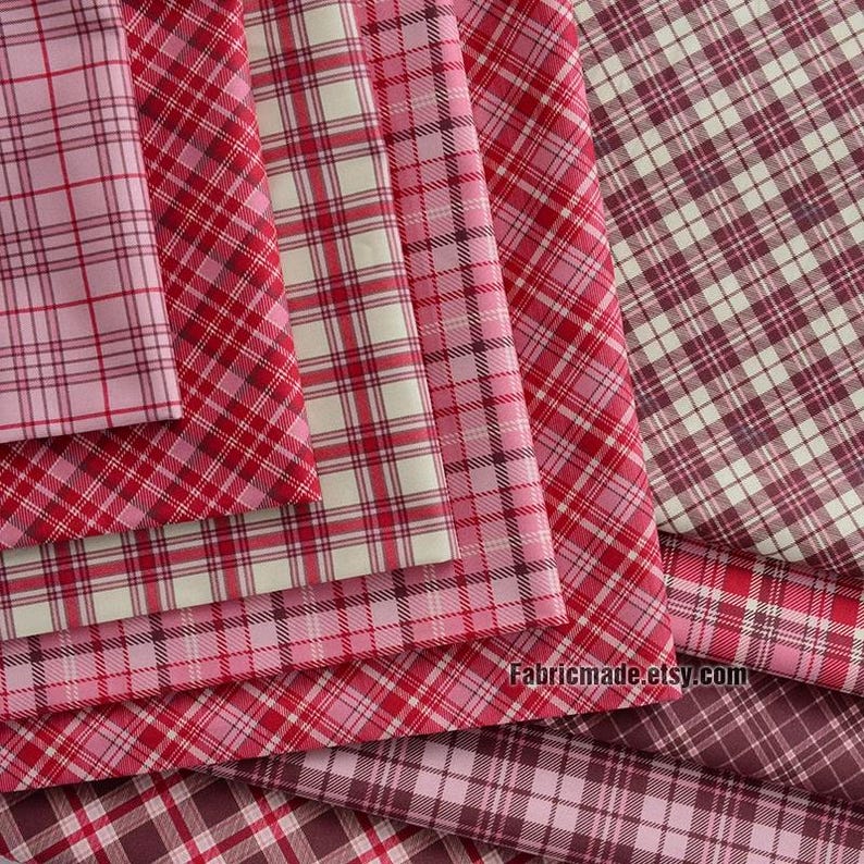 May include: A stack of red and white plaid fabric with a pink and white plaid fabric on top. The fabric is folded in a way that shows the different patterns. The text "Fabricmade.etsy.com" is visible at the bottom of the image.