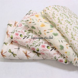 May include: Four different fabric swatches featuring floral and dragonfly patterns. The fabrics are all white with watercolour-style designs in shades of green, pink, and yellow. The text "Fabricmade.etsy.com" is printed on the fabric.