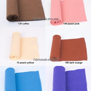 Op de afbeelding: Zes rollen geribbelde brei in verschillende kleuren, waaronder koffie, perzikroze, perzikgeel, donkeroranje, denimblauw en paars. Elke rol is gelabeld met een nummer en een kleurnaam.