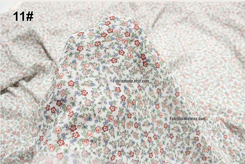 Peut inclure: Tissu en coton blanc avec un imprim&eacute; floral &agrave; petite &eacute;chelle dans des tons de rouge, rose, bleu et vert.