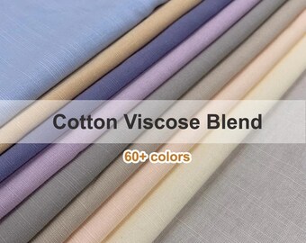Può includere: Una selezione di campioni di tessuto misto cotone e viscosa in vari colori, tra cui azzurro, beige, viola e grigio. Il testo "Cotton Viscose Blend" e "60+ colors" è visualizzato sull'immagine.