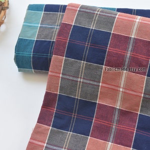 May include: Two pieces of plaid fabric, one teal and gray, the other red, gray, and navy blue. The fabric is folded and the text "Fabricmade.etsy.com" is visible in the bottom right corner.
