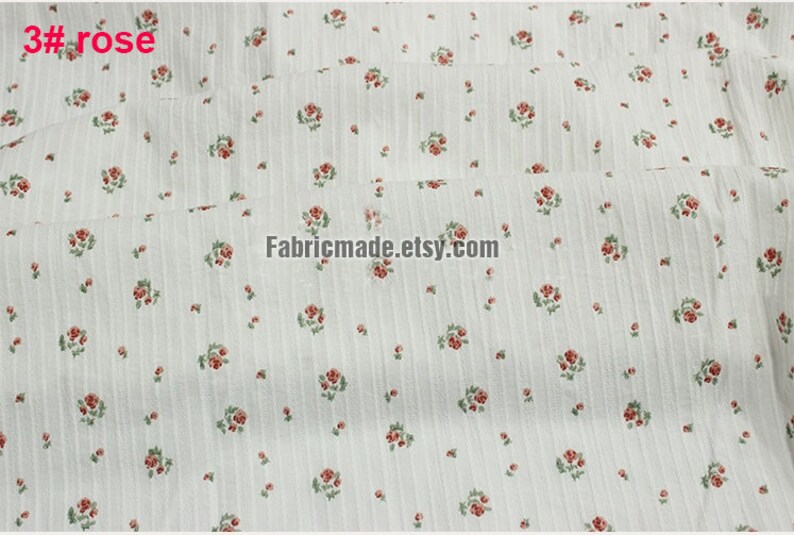 May include: White fabric with a small red rose print and thin vertical stripes. The fabric is folded in half and the text "Fabricmade.etsy.com" is printed on the fabric.