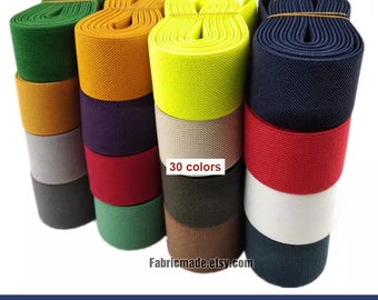 May include: A collection of 30 colours of 1.5 inch wide elastic band. The elastic band is woven with a textured pattern. The colours include green, orange, yellow, blue, red, white, grey, brown, and purple.