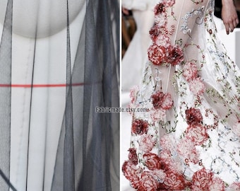 Può includere: Due pezzi di tessuto trasparente. Uno è nero e l'altro è bianco con fiori ricamati rossi. Il tessuto bianco ha la scritta "Fabricmade.etsy.com" stampata.