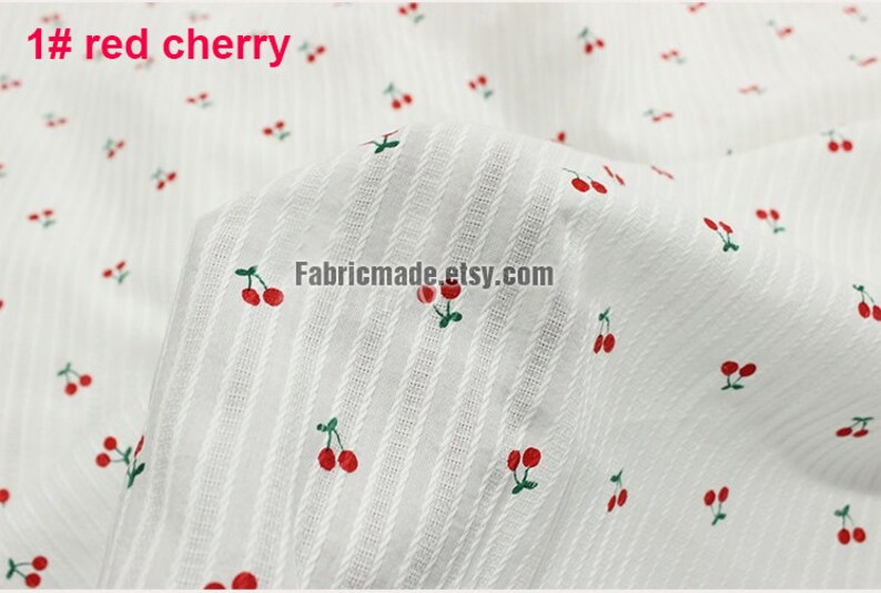May include: White fabric with a repeating pattern of red cherries. The fabric has a subtle striped texture. The text "1# red cherry" is visible in the top left corner.