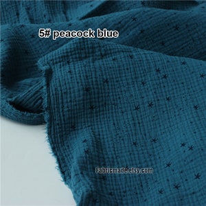 May include: Close-up of peacock blue fabric with a crinkled texture and small black star patterns. The text "5# peacock blue" is visible. The fabric is likely cotton or a similar material, suitable for apparel or home decor.