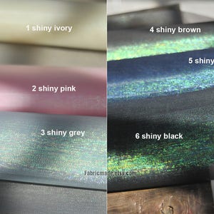 May include: Close-up of six fabric swatches in various colors: ivory, pink, grey, brown, blue, and black. Each swatch has a shiny, iridescent finish. The text "Fabricmade.etsy.com" is visible.