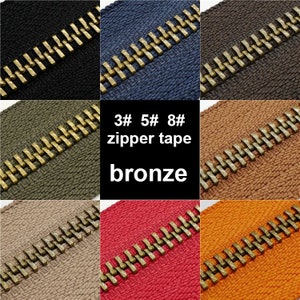 May include: Close-up of six zipper tapes in different colors with bronze zipper teeth. The tapes are labeled "3# 5# 8# zipper tape bronze".