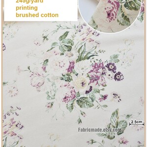 Puede incluir: Primer plano de una tela de algod&oacute;n blanca con estampado floral con flores moradas y verdes. La tela es 100% algod&oacute;n, tiene 115 cm de ancho y pesa 245 gramos por yarda. La tela se describe como "2 purple, printing, brushed cotton".