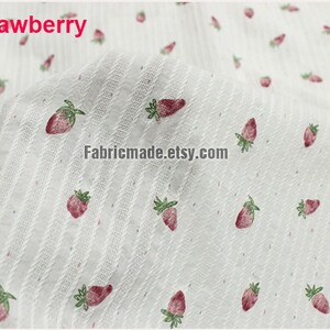 May include: White fabric with a subtle striped pattern and a repeating print of red strawberries. The fabric is labeled "4# strawberry".