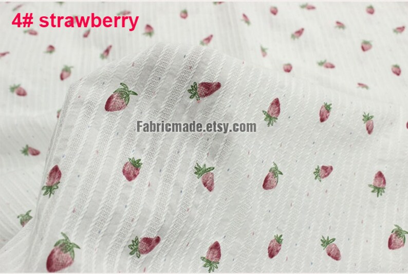 May include: White fabric with a subtle striped pattern and a repeating print of red strawberries. The fabric is labeled "4# strawberry".