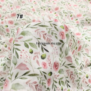 May include: White cotton fabric with a delicate floral pattern featuring pink roses and green leaves. The fabric has a watercolour effect and is perfect for crafting projects. The text "7#" is visible in the top left corner of the image.