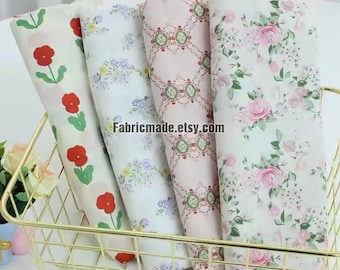 May include: Four rolls of fabric with floral patterns in a gold wire basket. The fabrics feature designs of red poppies, blue and yellow flowers, a pink damask pattern, and pink roses. The Etsy shop name "Fabricmade.etsy.com" is visible.