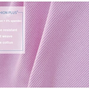 K&ouml;nnte beinhalten: Nahaufnahme eines helllila Stoffes mit feiner Webart. Der Stoff wird als knitterarm, flachgewebt und aus 95 % Baumwolle und 5 % Elasthan beschrieben. Der Text "FASHION PLUS+" ist oben links sichtbar.