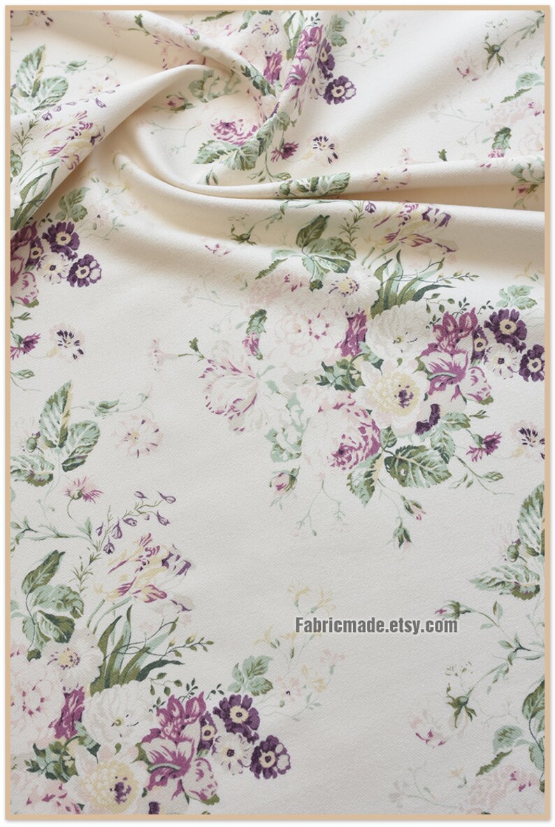 Puede incluir: Tela blanca con estampado floral con flores rosas, moradas y verdes. La tela tiene una textura sutil y un drapeado suave y fluido.