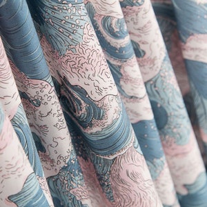 May include: Close-up of fabric with a repeating wave pattern in shades of blue, pink, and white. The design resembles a traditional Japanese woodblock print, with stylized waves and foam. The fabric is folded, creating depth and texture.