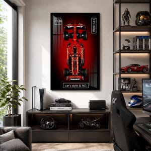 Puede incluir: Un cuadro decorativo rectangular que muestra una vista cenital de un coche de carreras de Fórmula 1 rojo sobre un fondo rojo oscuro y negro. El cuadro incluye bordes rectangulares blancos con el texto F's BR, FR's BR&L y car's style & NO.