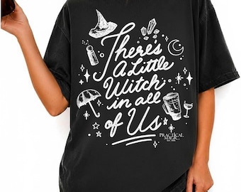 Puede incluir: Una camiseta negra de manga corta con gráficos de líneas blancas de un sombrero de bruja, cristales, una luna creciente, un paraguas y un vaso. El texto dice "There's A Little Witch in all of Us" y "PRACTICAL MAGIC EST. 1998" en letra blanca.