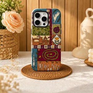 Könnte beinhalten: Eine Smartphone-Hülle mit einer mehrteiligen Illustration in einer Farbpalette aus Blau, Grün, Rot und Orange. Das Design zeigt einen Hasen, einen Granatapfel, eine Burg, eine Blume, eine Schlange, ein Schwert und brennende Kerzen.