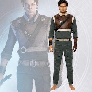 Könnte beinhalten: Ein Kostümset bestehend aus einem dunkelgrauen Langarmshirt, einer passenden Cargohose mit gerippten Kniepartien und einem braunen Brustgurt aus Kunstleder mit diagonalem Riemen. Das Outfit umfasst einen beigen Gürtel und braune Armstulpen.