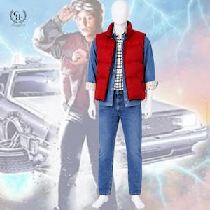Könnte beinhalten: Ein Kostüm-Set bestehend aus einer leuchtend roten Steppweste über einem blauen Jeanshemd, einem weiß-schwarz karierten Hemd und einer blauen Jeanshose. Das Outfit wird auf einer weißen Schaufensterpuppe vor einem Auto präsentiert.