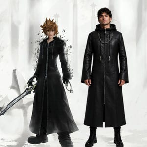 May include: A long black hooded coat with a full-length front zipper, long sleeves, and a silver chain detail across the chest. The coat features a structured hood and a smooth finish, reaching down to the mid-calf, paired with black boots.