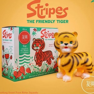 May include: A yellow and black toy tiger with the text "Stripes The Friendly Tiger". The toy is next to a box with the same tiger illustration and text. The box has the text "Toy Aimed at the Hearts of Children".