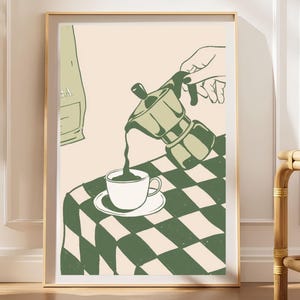 Puede incluir: Una lámina de arte mural enmarcada con una ilustración gráfica de una mano vertiendo café de una cafetera italiana verde en una taza blanca. La escena se sitúa sobre una mesa con un mantel de cuadros verdes y crema, con una bolsa parcial al fondo.